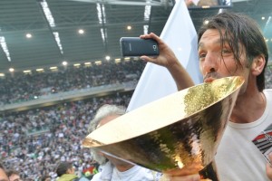 Juventus' goalkeeper Gianluigi Buffon kisses the Italian Serie A football trophy, the Scudetto, during a ceremony after the team's match against Atalanta on May 13, 2012 in Juventus stadium in Turin. Juve have officially won 28 titles due to having been stripped of their 2005 and 2006 successes for match-fixing and forward Alessandro Del Piero's 19-year stay with the Old Lady Juventus will come to an end this summer.       AFP PHOTO / GIUSEPPE CACACEGIUSEPPE CACACE/AFP/GettyImages